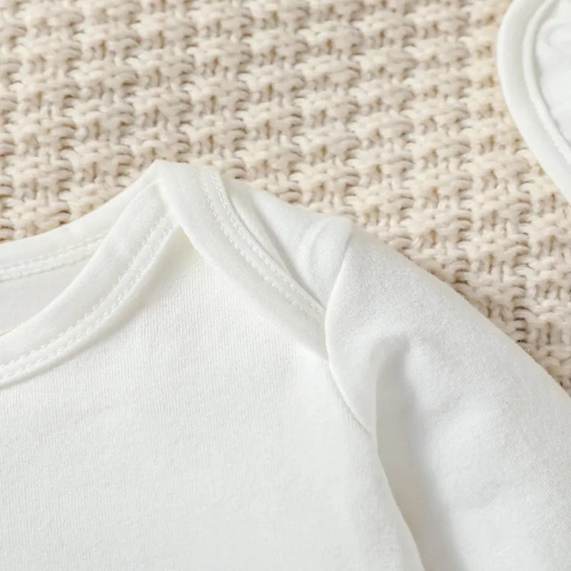 Body bébé garçon blanc doux en coton sur couverture tricotée