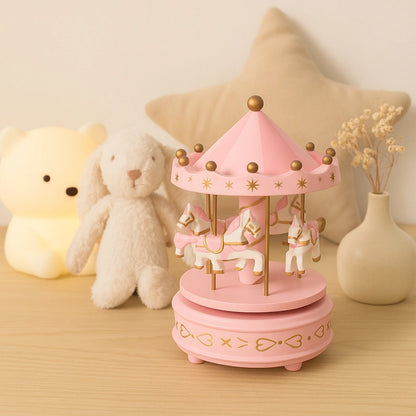 Boîte à musique carrousel rose sur table avec peluches et décoration douce pour bébé fille.