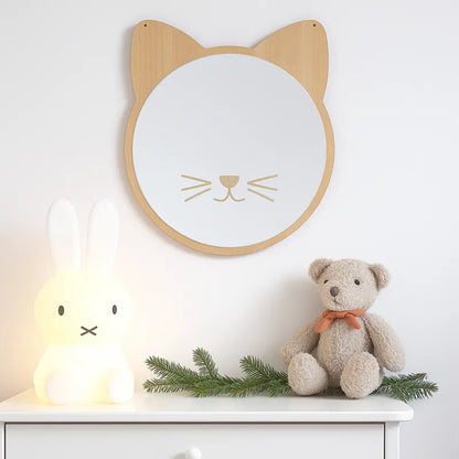 Miroir chat en bois clair sur commode blanche avec peluche et veilleuse.