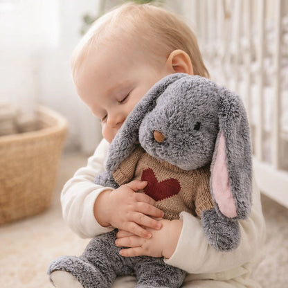 Bébé câlinant une peluche lapin gris douce avec cœur rouge, doudou rassurant pour sommeil et confort enfant
