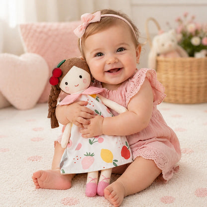 poupée en tissu pour bébé motif fruits tenue par un bébé fille dans une chambre enfant décor doux