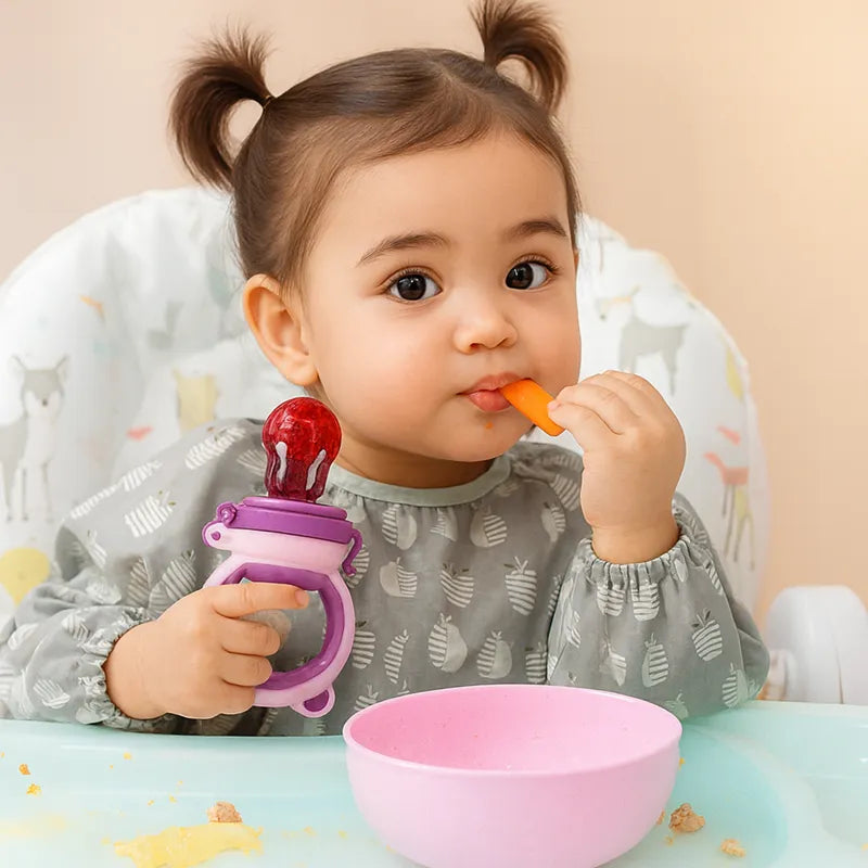 Bébé fille mangeant des fruits avec une mangeoire en silicone sans BPA