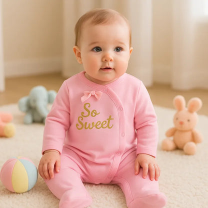 Bébé fille assise en pyjama rose doux avec inscription So Sweet