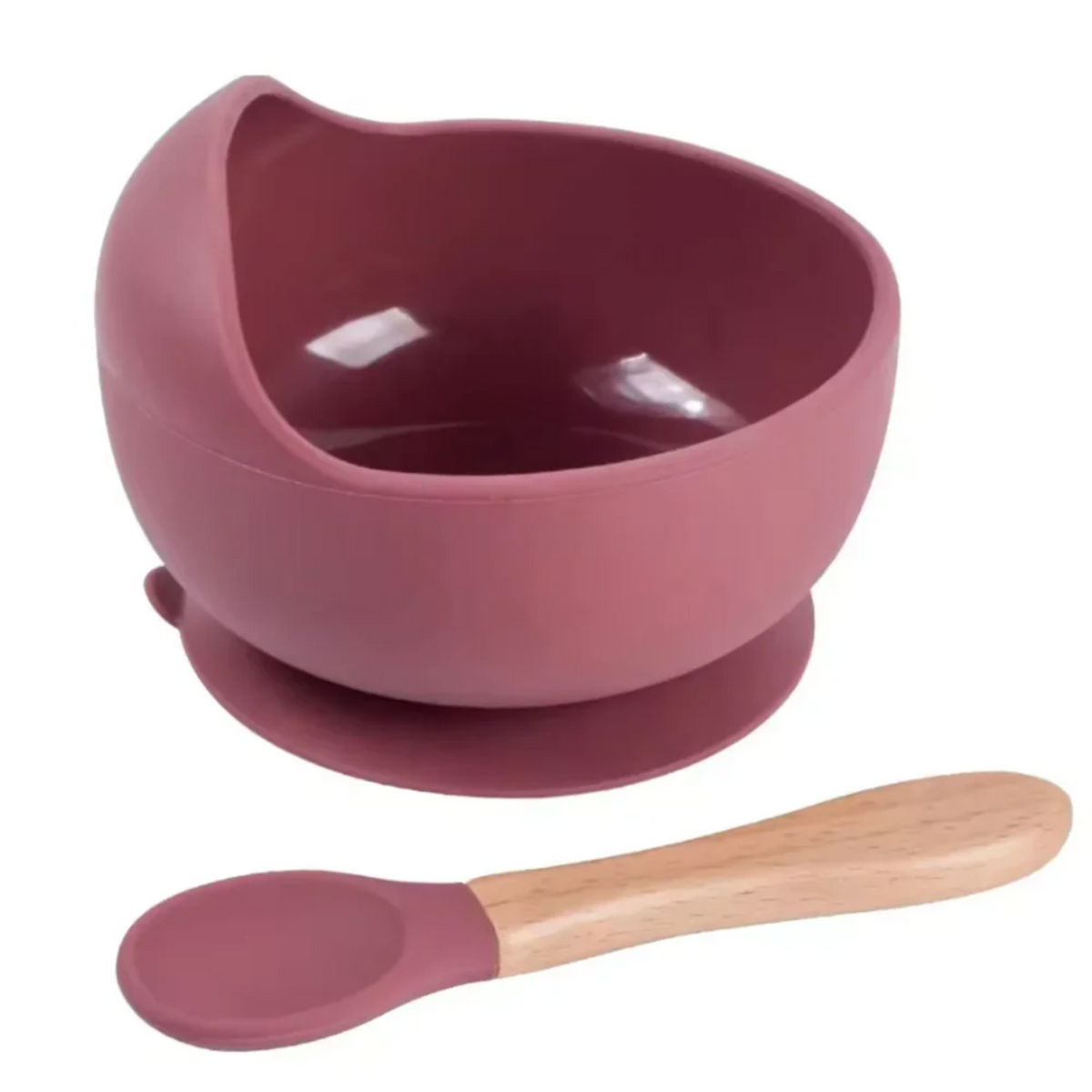 Bol en silicone vieux rose pour bébé avec rebord haut et base à ventouse, accompagné d'une cuillère assortie à manche en bois sur fond blanc.