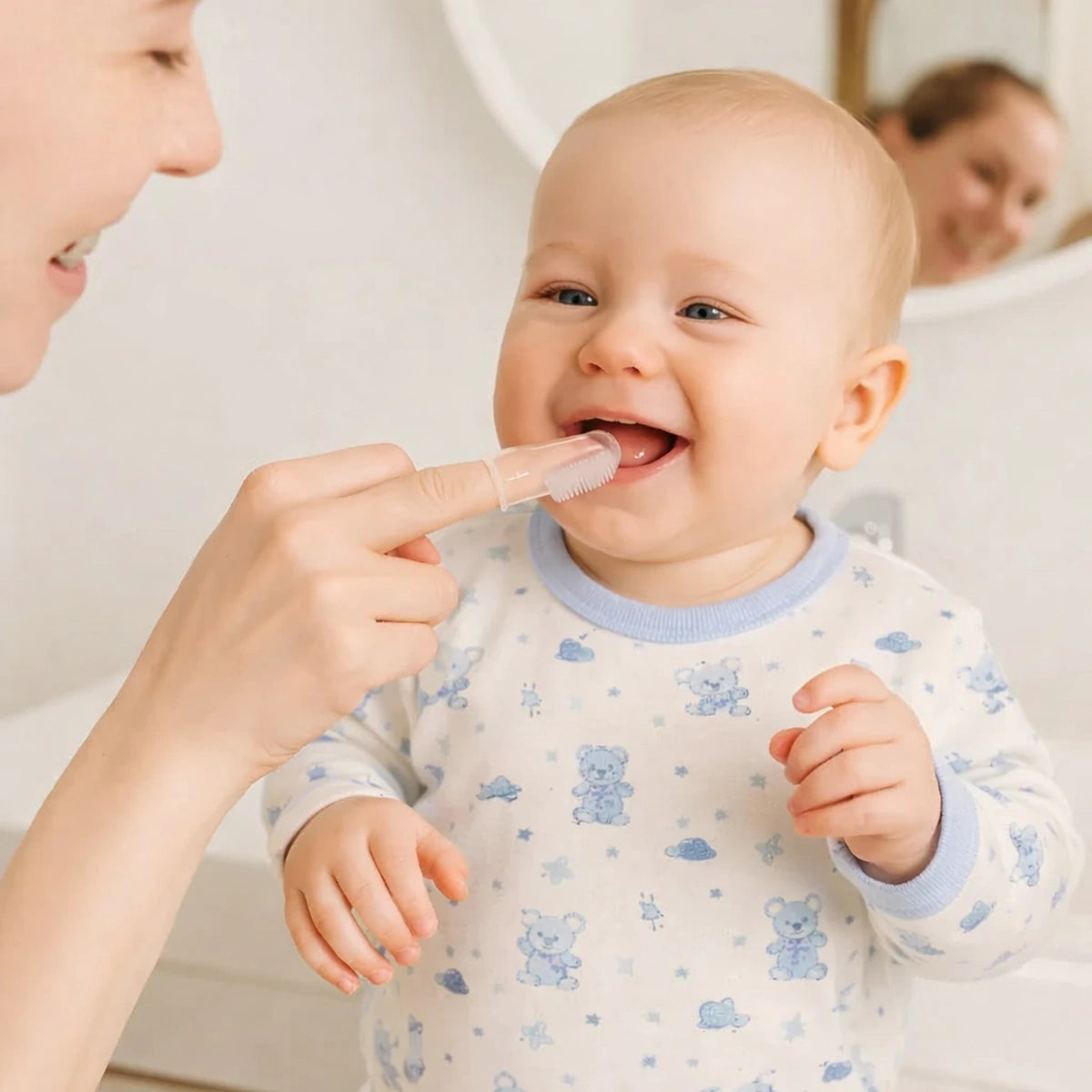 Maman nettoyant les dents de son bébé avec une brosse à dents bébé en silicone ergonomique et sécurisée
