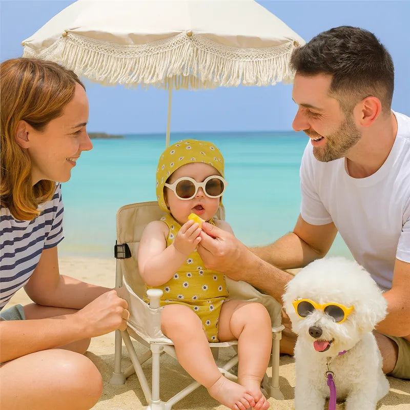 Chaise de voyage bébé pliable sur la plage avec parents et chien
