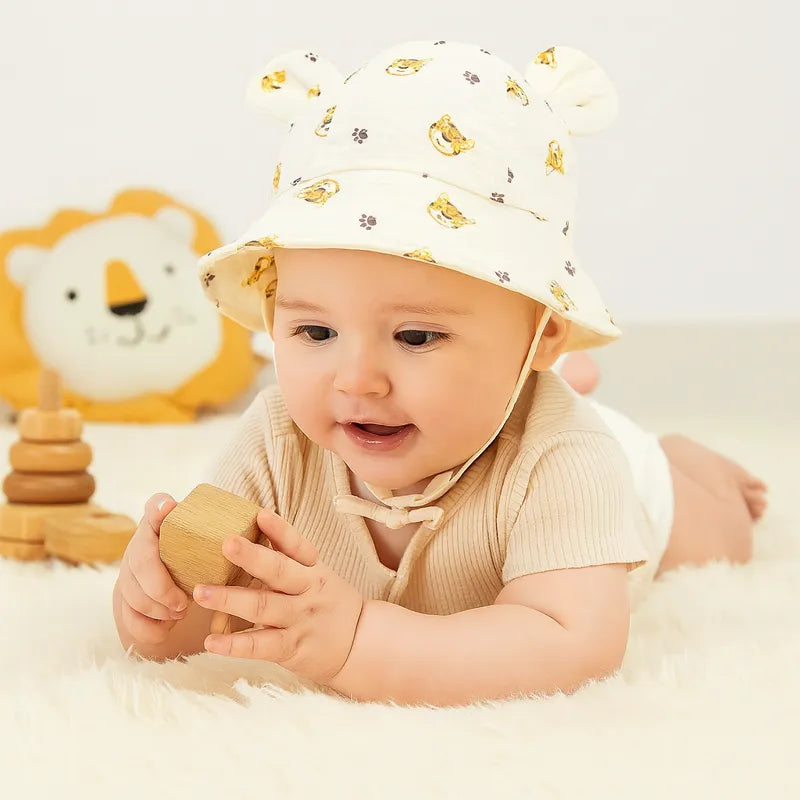 Bébé jouant sur tapis moelleux avec chapeau imprimé tigre mignon.