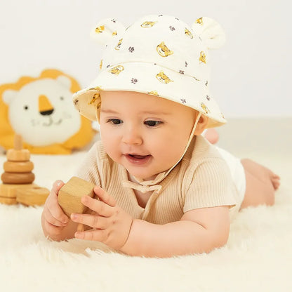 Bébé jouant sur tapis moelleux avec chapeau imprimé tigre mignon.