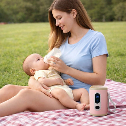 Maman donnant le biberon à son bébé en pique-nique avec chauffe biberon portable USB