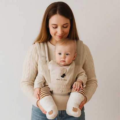 Maman portant son bébé en porte-bébé avec des chaussettes bébé chaudes épaisses blanches motif ourson.