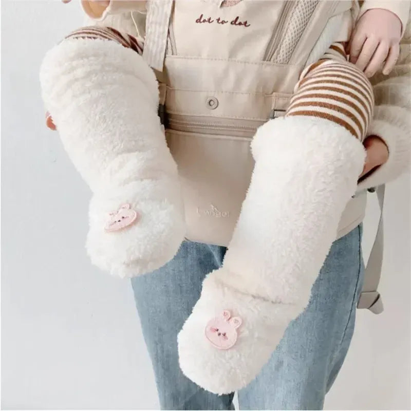 Bébé en porte-bébé portant des chaussettes bébé chaudes blanches en peluche avec motif lapin brodé.
