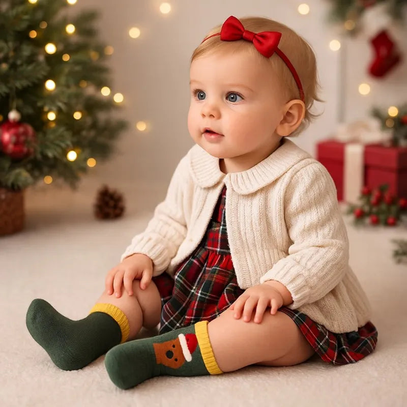 Bébé portant des chaussettes bébé Noël motifs renne dans décor festif”