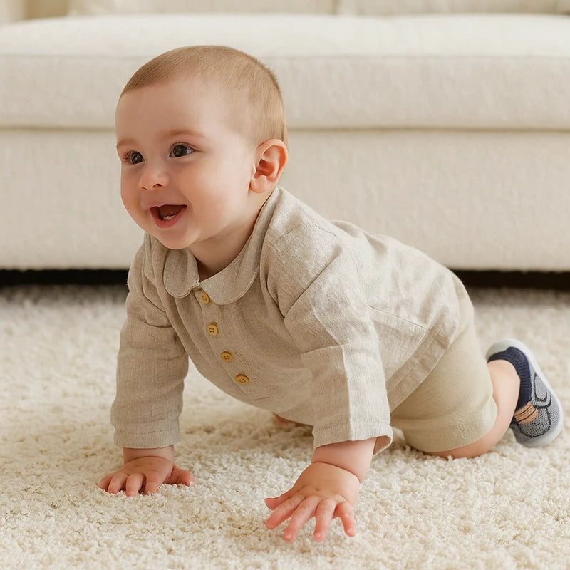 Chaussures bébé légères et respirantes bleu marine pour premiers pas sur tapis beige