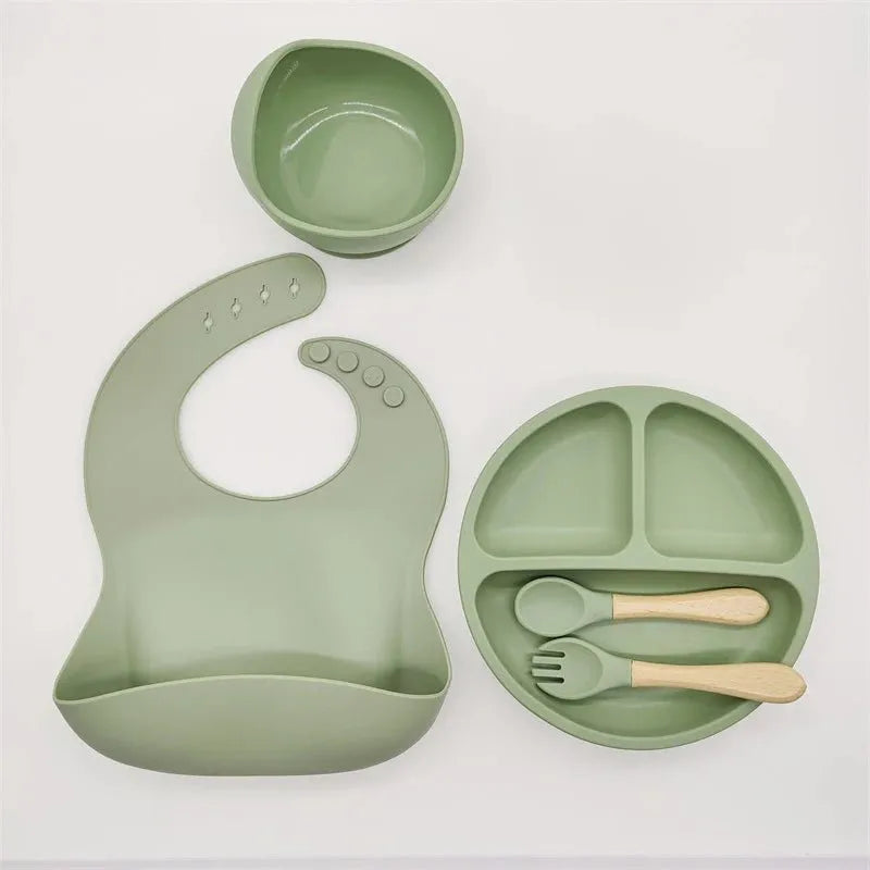 Coffret vaisselle bébé en silicone vert avec assiette compartimentée, bol, cuillère, fourchette et bavoir sans BPA