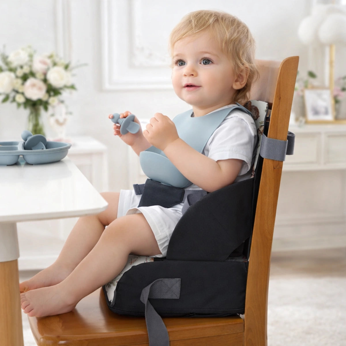 coussin rehausseur enfant noir installé sur chaise vue de profil montrant la position ergonomique du bébé