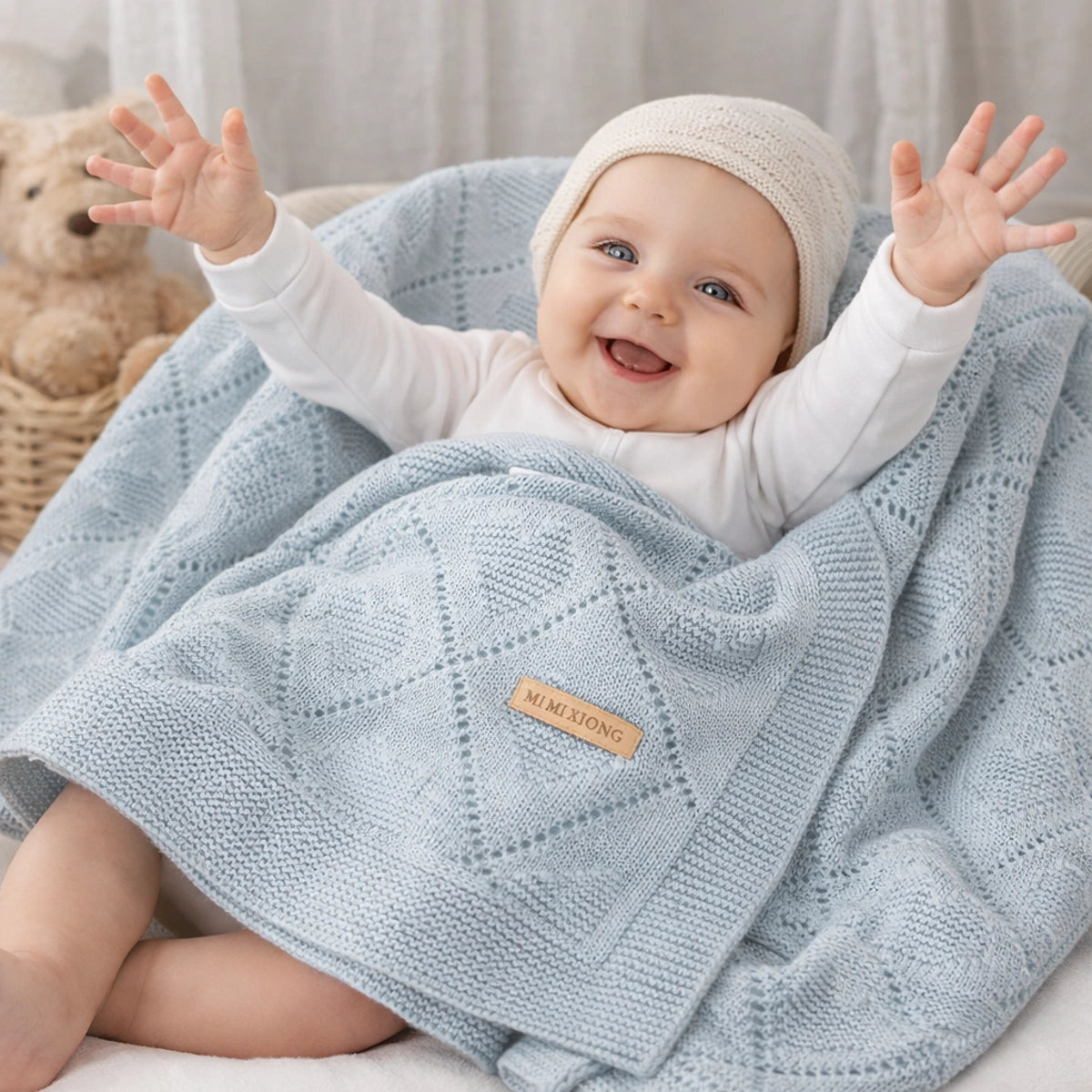 Bébé souriant enveloppé dans une couverture tricotée bleu clair douce et confortable dans une chambre cocooning