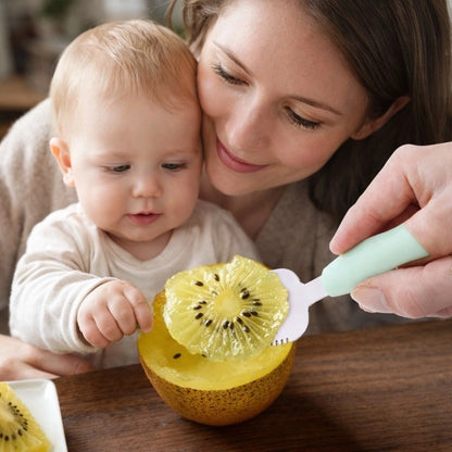 Maman nourrissant bébé avec cuillère fruit bébé pour découper kiwi, accessoire alimentation autonome bébé