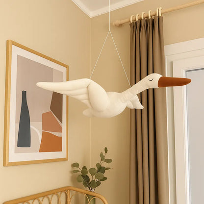 Décoration murale cygne en peluche suspendue dans une chambre bébé beige, ambiance douce et scandinave.