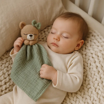 Bébé endormi tient un doudou ourson en coton vert sauge doux