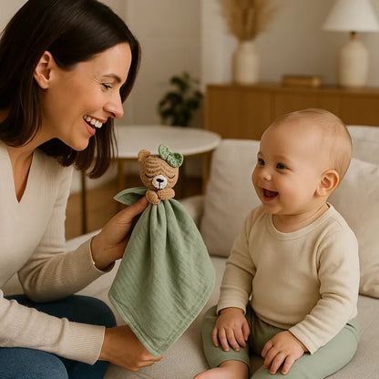 Maman souriante joue avec bébé et son doudou ourson vert sauge
