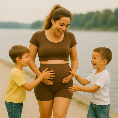 Maman enceinte en ensemble maternité jouant avec ses enfants à la plage
