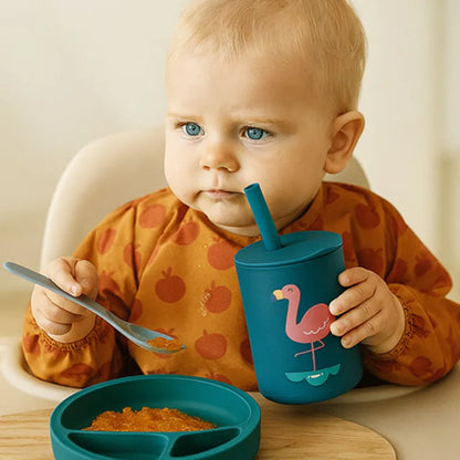 Bébé utilisant un gobelet apprentissage bleu avec flamant rose