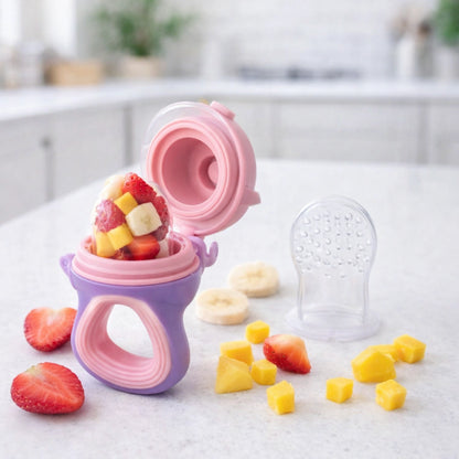 Grignoteuse bébé silicone remplie de fruits frais sur comptoir cuisine, mangeoire fruits sécurisée pour autonomie bébé