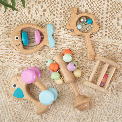 Ensemble de cinq hochets en bois Montessori conçus pour favoriser l'éveil sensoriel, la préhension et la coordination de bébé.