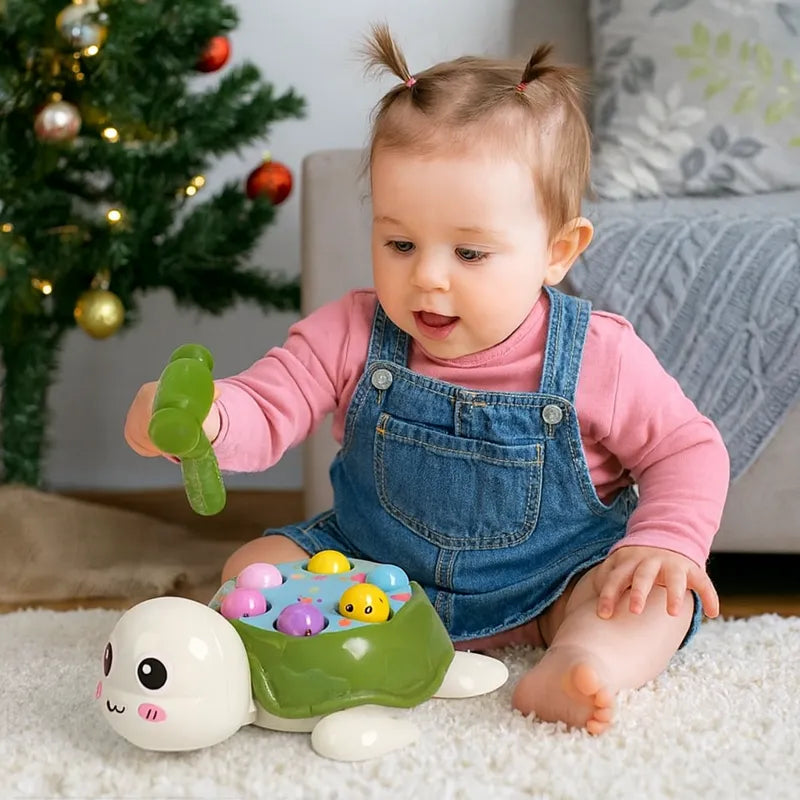 Bébé fille joue avec le jouet tortue à marteau Montessori devant le sapin de Noël, jeu d’éveil éducatif pour développer la motricité fine.