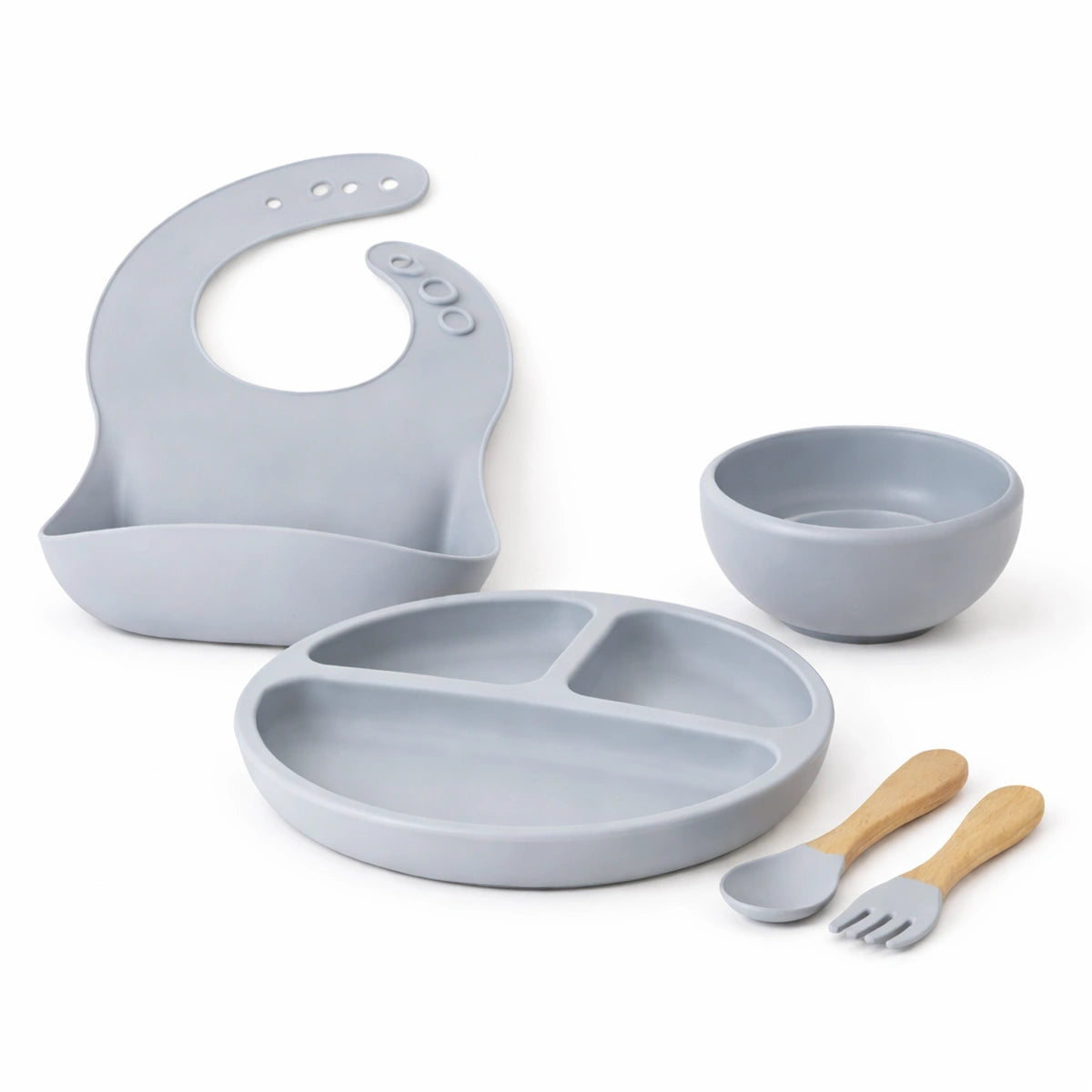 Kit repas bébé en silicone gris sans BPA avec bavette, assiette compartimentée, bol et couverts en bois sur fond blanc