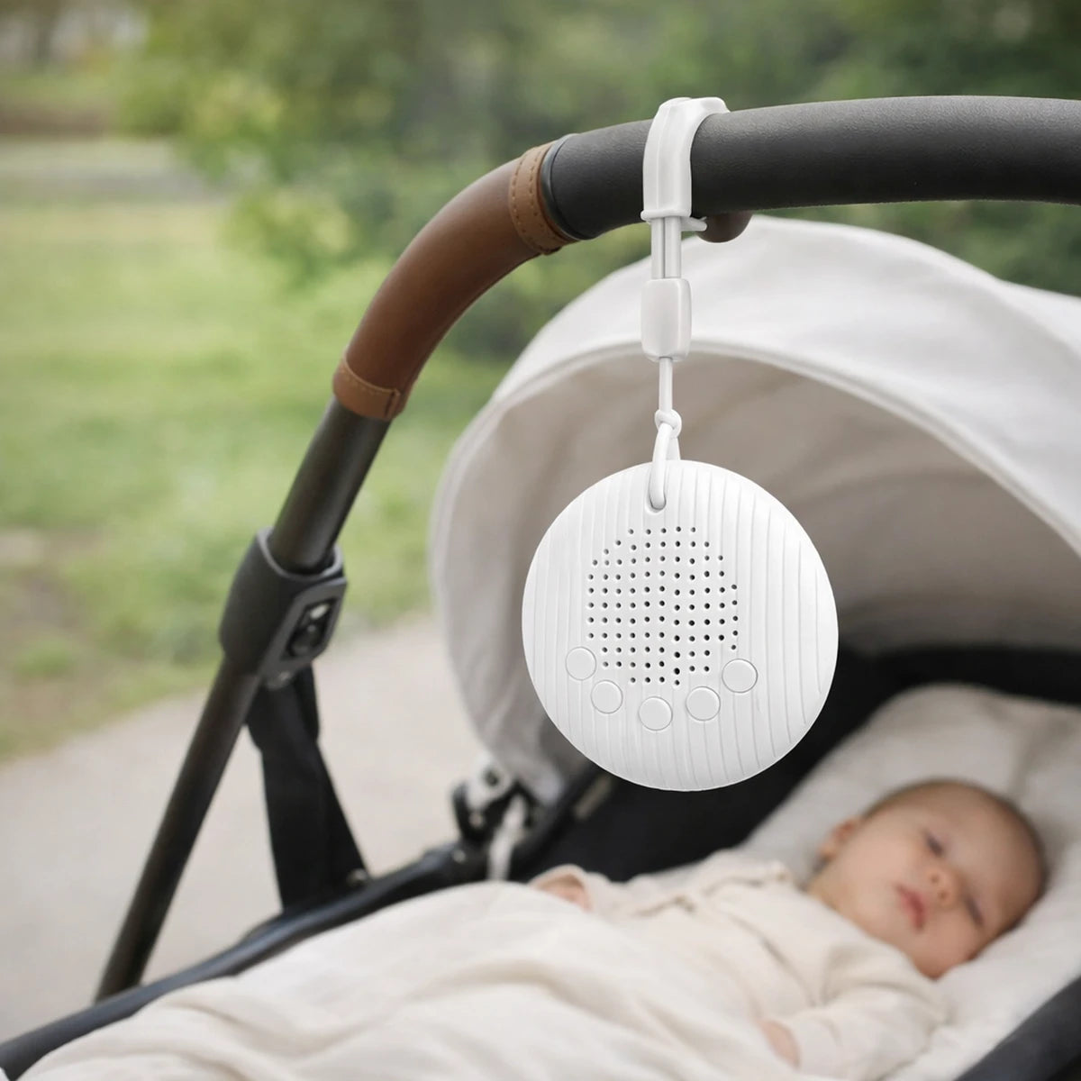 Machine à bruit blanc bébé accrochée à une poussette