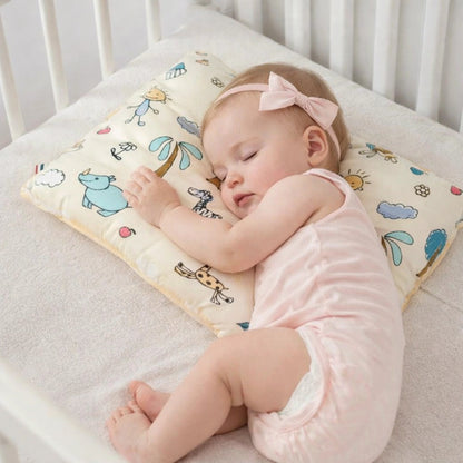 Bébé dormant sur oreiller ergonomique anti tête plate pour nouveau-né dans un lit bébé sécurisé