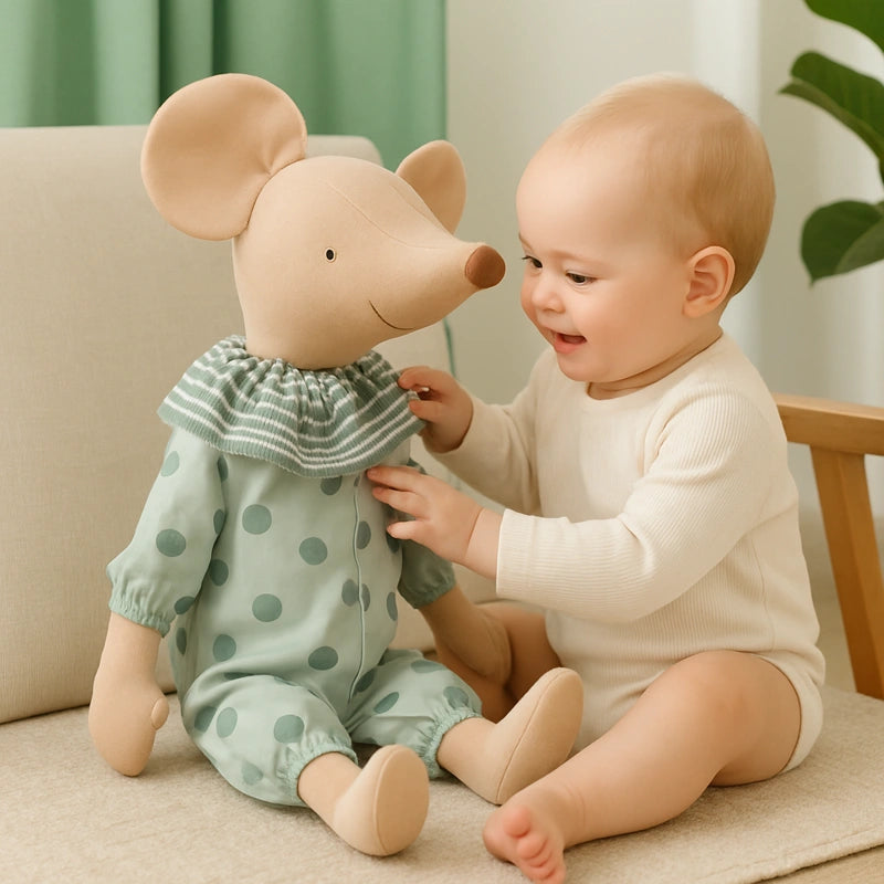 Bébé souriant jouant avec peluche souris verte en coton assis sur un fauteuil