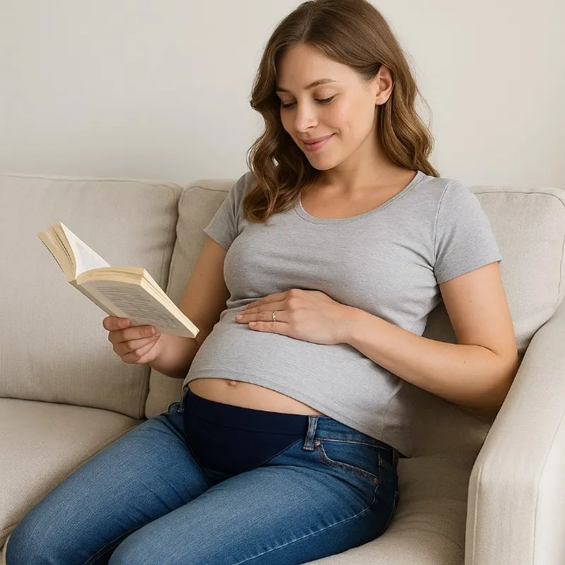 Femme enceinte assise lisant avec rallonge pantalon maternité