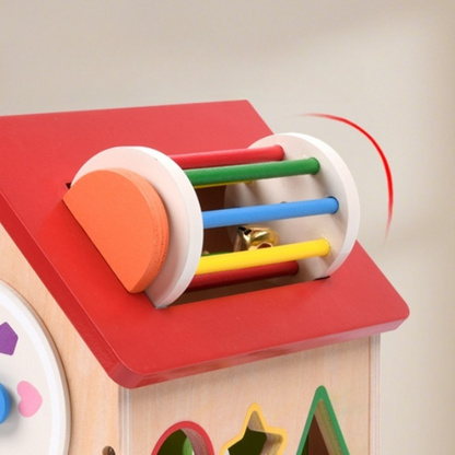 Rouleau d'activités coloré sur le toit d'une maison d'activités en bois Montessori pour développer l'éveil sensoriel de bébé.