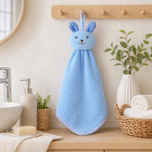 Serviette bébé bleue à capuche avec motif lapin suspendue dans une salle de bain moderne