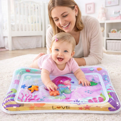 Bébé fille jouant sur tapis d’eau bébé sirène rose avec maman en arrière-plan dans chambre lumineuse