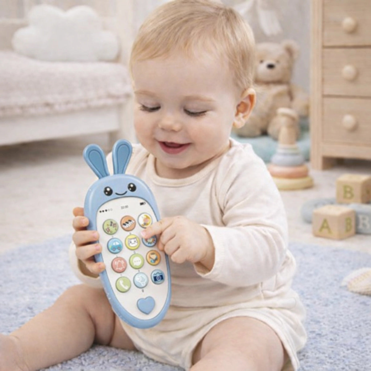 Bébé tenant un téléphone jouet bleu éducatif avec boutons musicaux pour éveil sensoriel