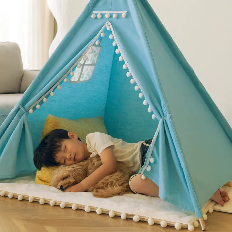 Enfant dormant avec un petit chien dans une tente tipi bleue