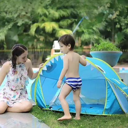 2 enfant qui s'amusent près de la tente de plage bleu