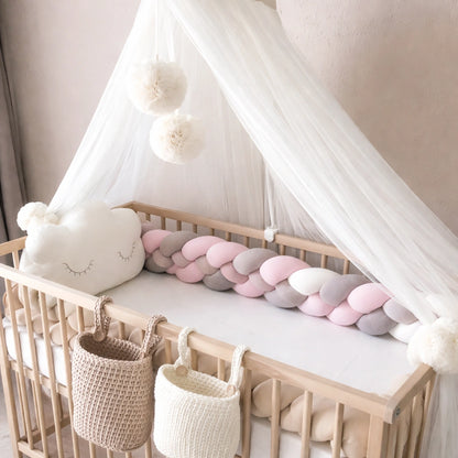 Tresse de lit bébé installée dans un lit en bois avec décor naturel et voile de lit,