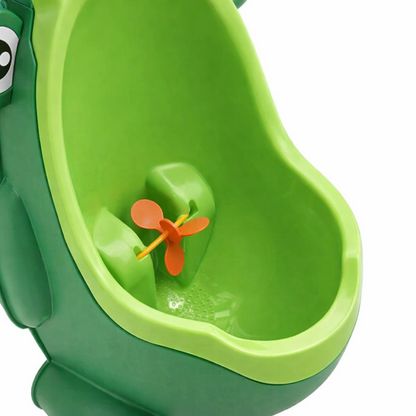 Gros plan sur l’intérieur de l’urinoir grenouille vert pour garçon avec hélice orange rotative.