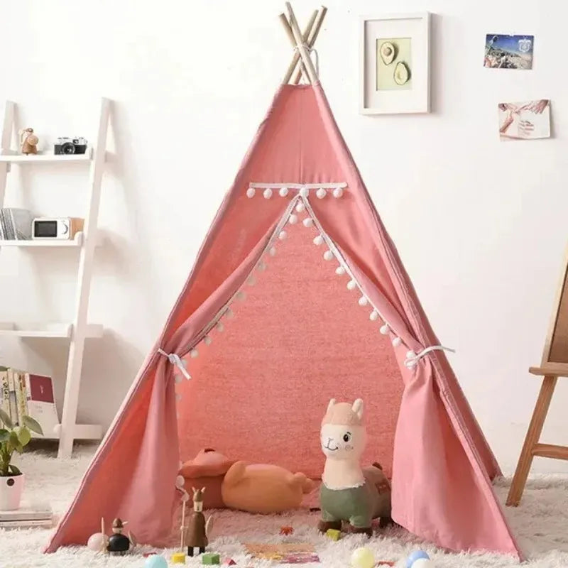 Tipi enfant rose avec pompons blancs et peluches décoratives au sol