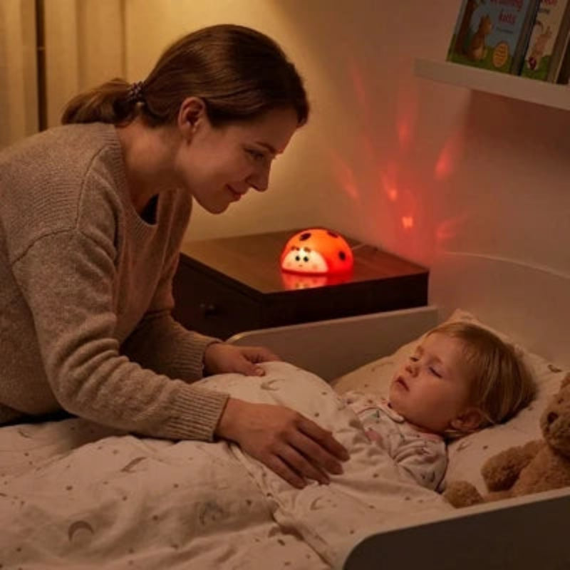 Maman bordant son enfant avec une veilleuse coccinelle LED rechargeable